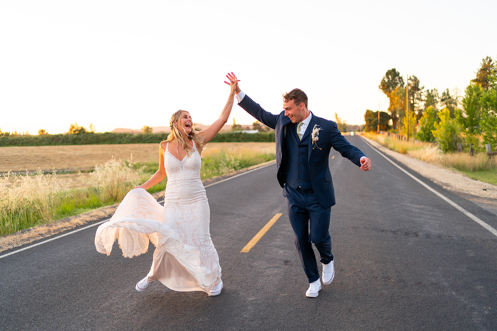 Newlywed couple dancing in the street at sunset